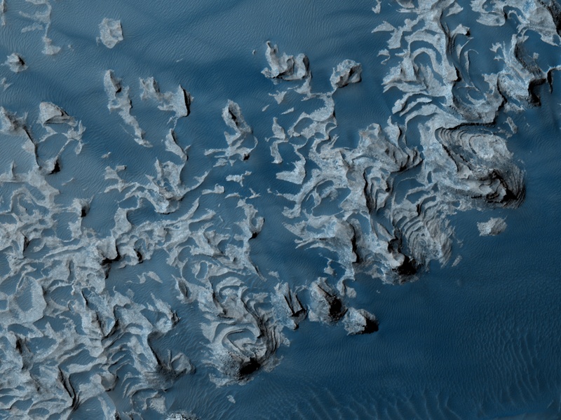 Diese Felsnasen auf der Marsoberfläche sind in Falschfarben-Blau dargestellt, sie erinnern an Ozeanwellen.