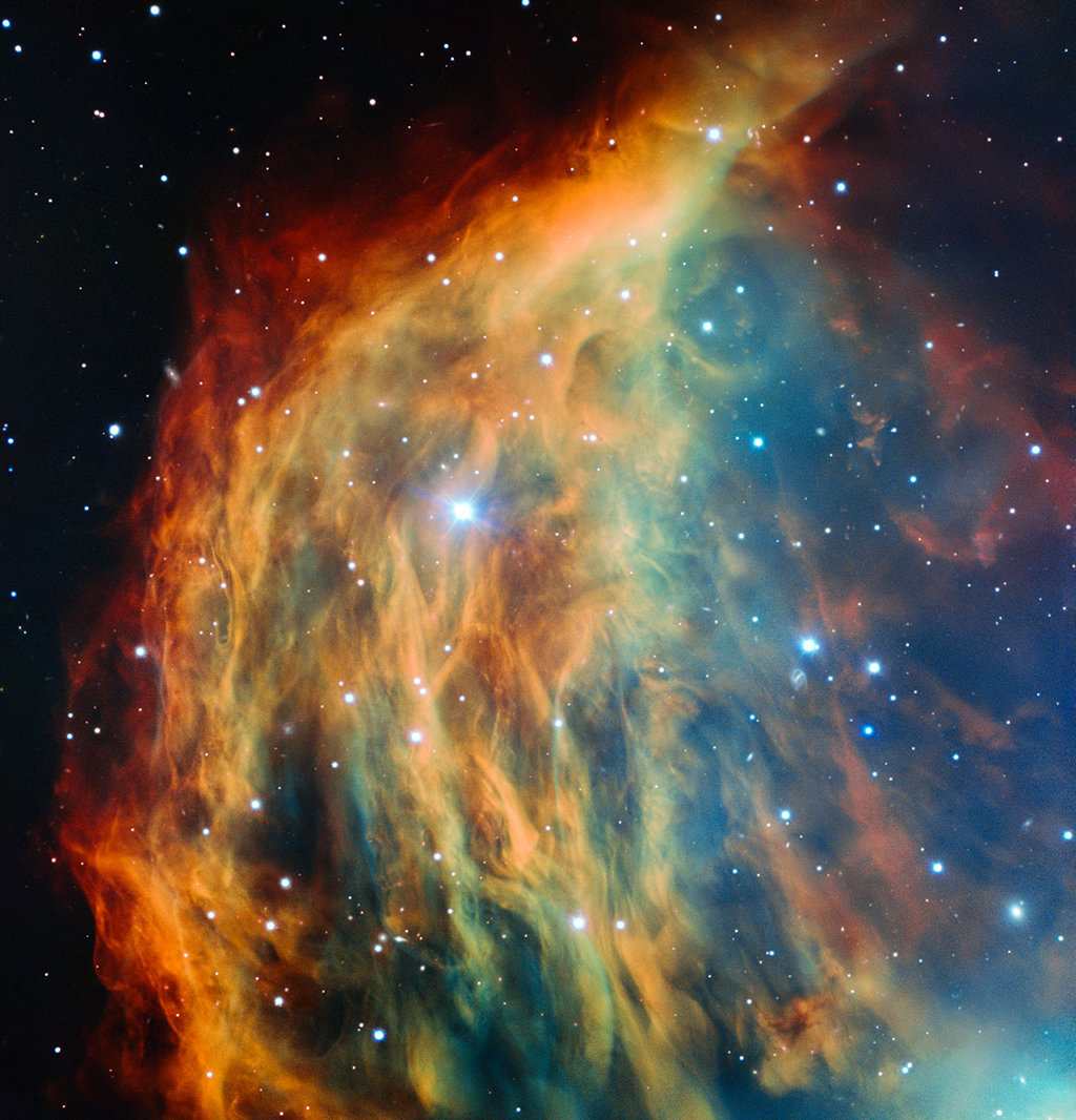 Der Medusanebel im Sternbild Zwillinge ist hier besonders farbenprächtig dargestellt. Links ist ein Bogen gefaserter roter Nebel, rechts daneben mischen sich orangefarbene und blaue Nebel. Auch der Stern, der seine Hülle abwirft, ist im Bild.