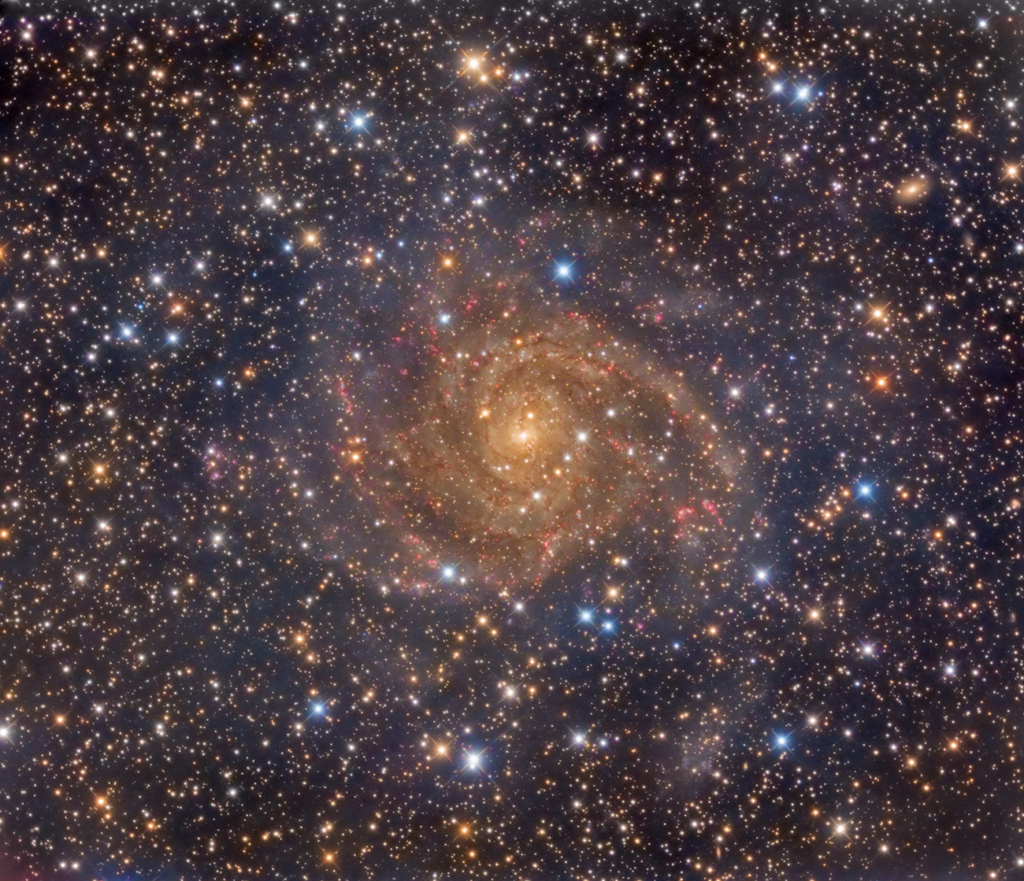 Hinter einem dichten Schleier aus Sternen und Nebel in unserer Milchstraße leuchtet die Spiralgalaxie NGC 342 mit ausladenden Spiralarmen.