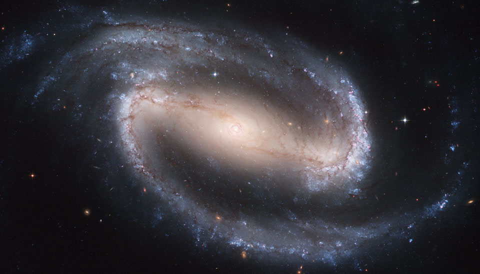 Die Spiralgalaxie NGC 1300 ist bildfüllend dargestellt. Sie hat einen so breiten Balken, dass sie wie eine Ellipse aussieht. Um den hellen Kern sind zwei markante Spiralarme gewunden.