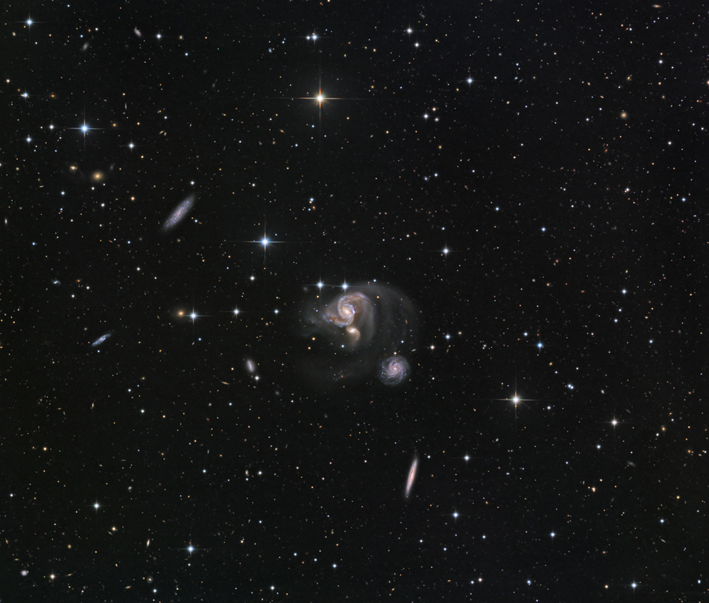 Die kompakte Hicksongruppe HCG 91 im Sternbild Südlicher Fisch liegt mitten im Bild. Außen herum sind weiter entfernte Galaxien verteilt, die ebenfalls blasse Spuren von Gezeitenschweifen aufweisen.