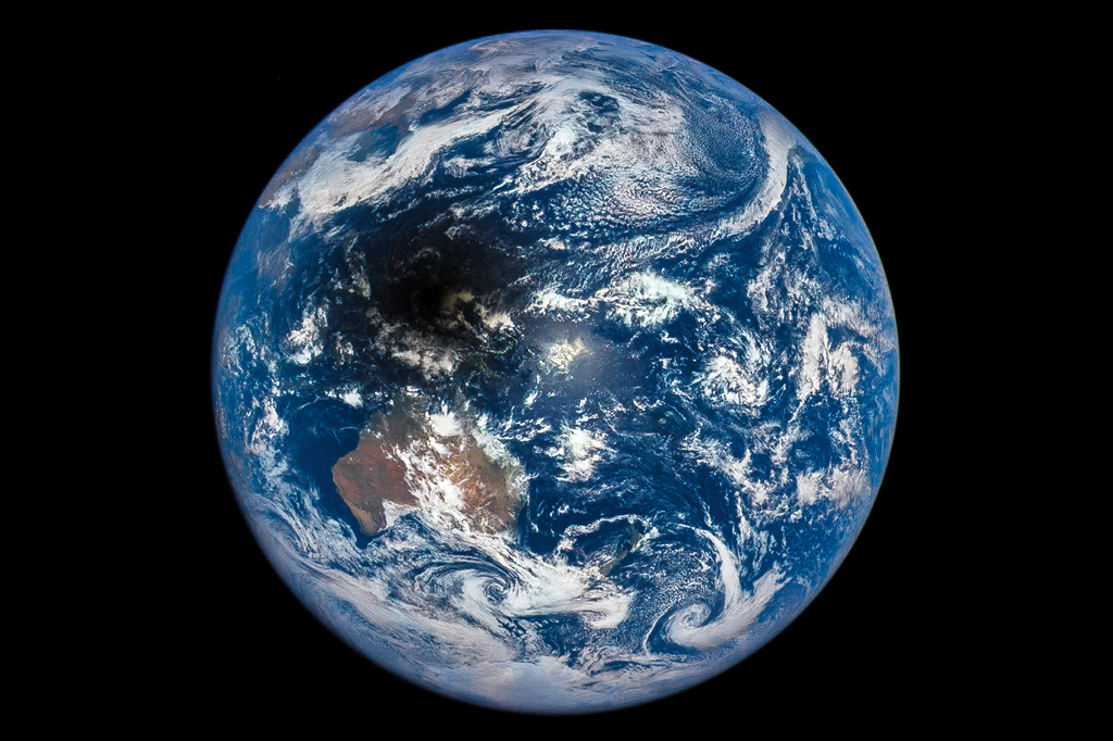 Auf der sonnenbeleuchteten Erde ist links oben ein dunkler Fleck. Es ist der Schatten des Mondes. Leute, die im Schatten stehen, sehen eine totale Sonnenfinsternis. Das Bild stammt vom Deep Space Climate Observatory (DSCOVR).