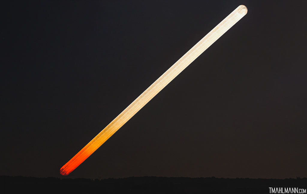 Der Mond geht auf und zieht einen breiten diagonalen Streifen im Bild. Tier über dem Horizont leuchtet er rötlich, die Farbe ändert sich schrittweise zu Hellgelb rechts oben.