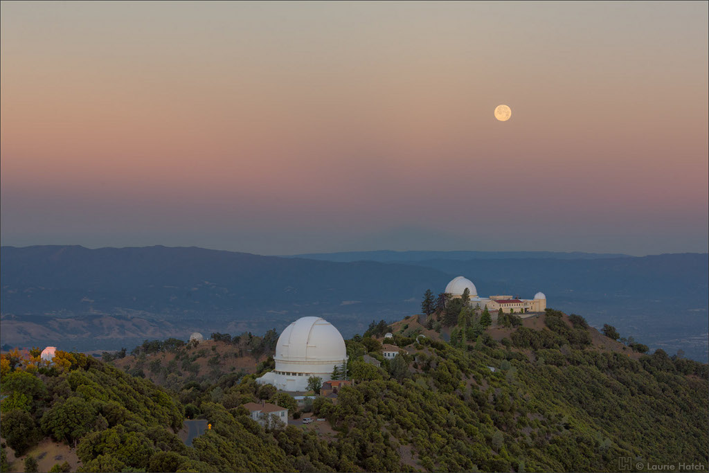 Über den Kuppeln des Lick-Observatoriums geht der Erdschatten mit dem Venusgürtel am Horizont unter. Im Venusgürtel leuchtet der Vollmond.