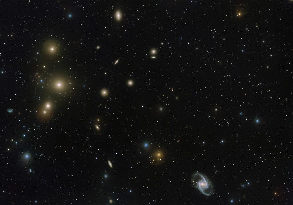 Fast jeder verschwommene gelbe Fleck im Bild ist eine elliptische Galaxie im Fornax-Galaxienhaufen. Rechts unten ist eine markante Balkenspiralgalaxie, sie leuchtet eher bläulich.