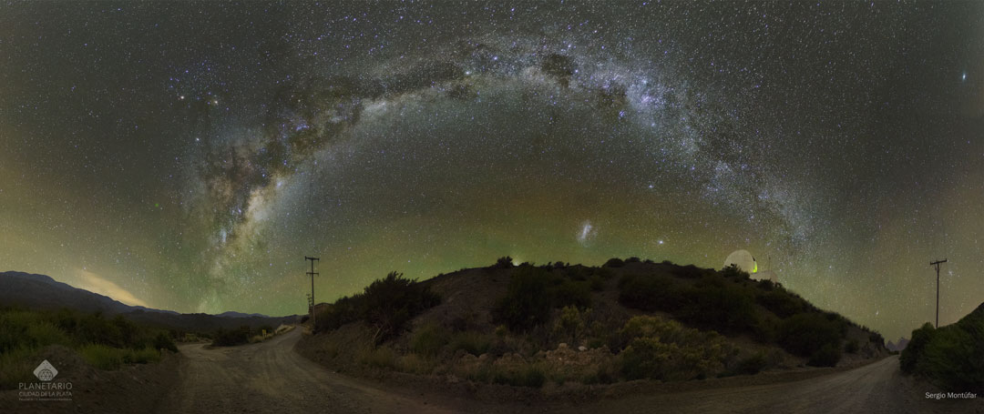 Über einem Hügel mit Sternwarte wölbt sich die prächtige Milchstraße. Am Himmel sind helle Sterne, Planeten, die Magellanschen Wolken und schließlich auch ein Komet verteilt.