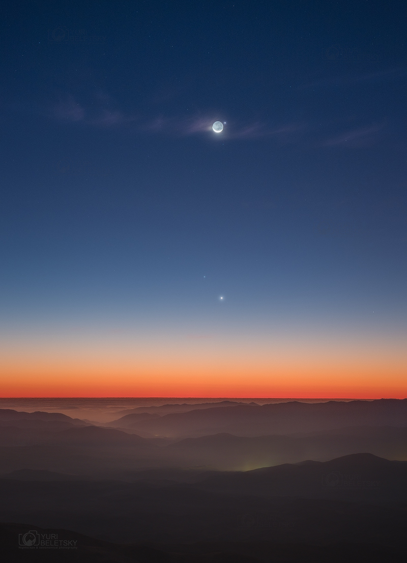 Über den chilenischen Bergen breitet sich ein malerisches Abendrot über dem Horizont aus. Nach oben hin wird der Himmel dunkelblau. Unten begegnet die Venus dem Stern Regulus, oben steht die Mondsichel mit beleuchteter Nachtseite knapp neben dem Planeten Merkur.