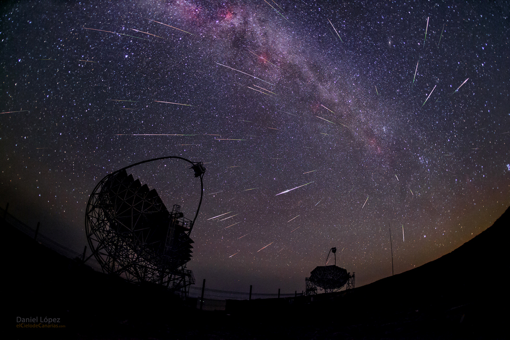 Über den dunklen Silhouetten der MAGIC-Teleskope auf La Palma wölbt sich die Milchstraße. Aus dem Sternbild Perseus zischen zahlreiche Meteore der Perseiden.