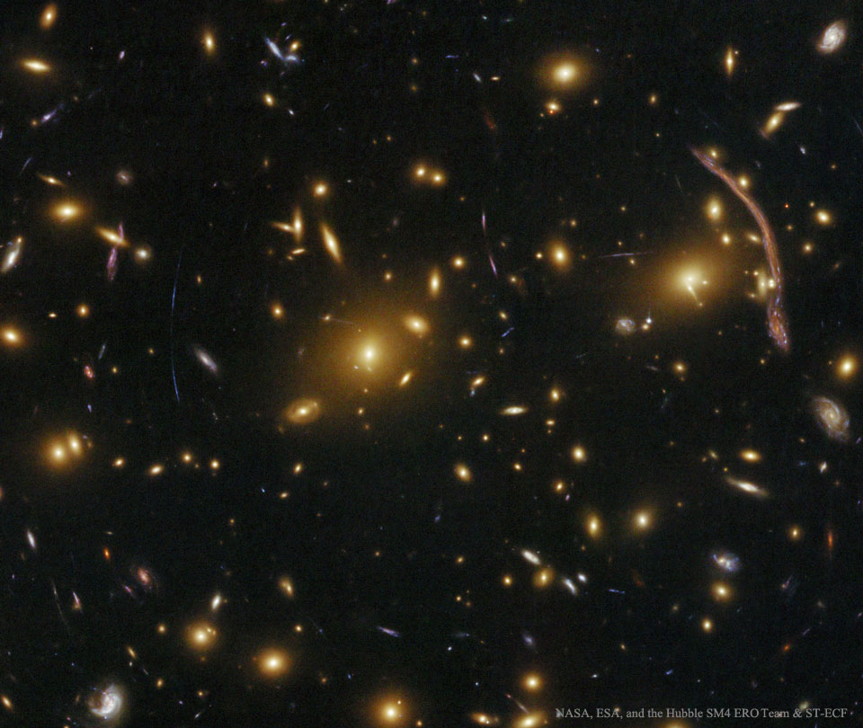 Der Bogen rechts oben im Bild von Abell 370 im Sternbild Walfisch wurde schon früh entdeckt, doch erst in den 1980er-Jahren fand man eine Erklärung dafür. Im Bild befinden sich viele weitere, aber kleinere Bögen. Sie stammen von Galaxien, die weit dahinter liegen.