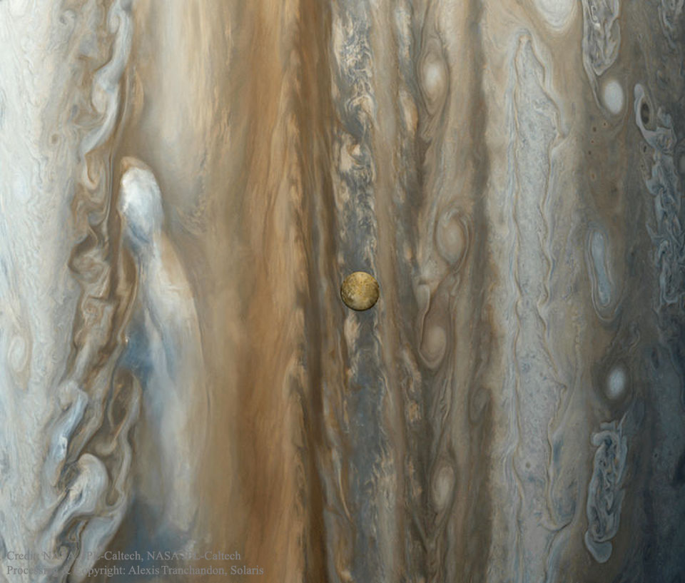 Vor Jupiters wirbelnden Wolken ist der Mond Io erkennbar. Das Bild entstand aus vielen Einzelaufnahmen. Auf Io sind runde Strukturen erkennbar, die sich später als Vulkane entpuppten.