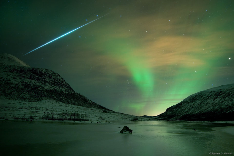 Über einem Gewässer bei der Insel Kvaløya in der Nähe der norwegischen Stadt Tromsø leuchteten im Dezember Polarlichter und Meteore der Geminiden. 