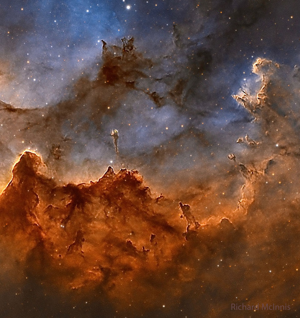 Das Bild ist voller gefaserter Nebel, unten wabert eine braune Nebelwand, darüber leuchten blaue Schleier, die von dunklen Fasern durchzogen sind.
