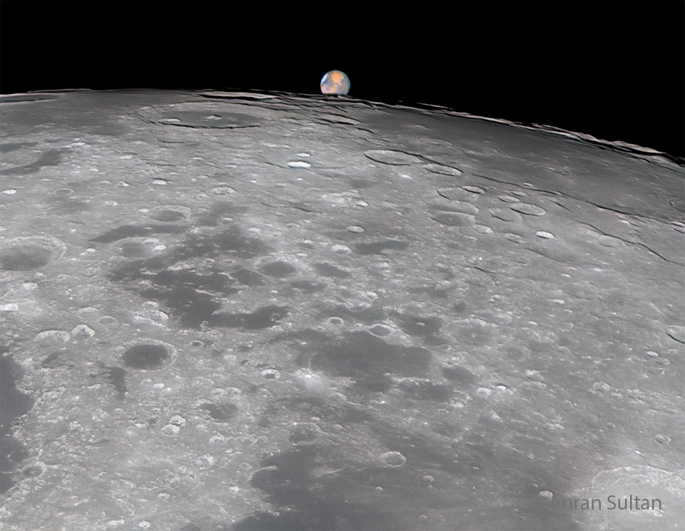 Der obere Teil des Mondes ist fast bildfüllend dargestellt. Am oberen Rand bedeckt er teilweise den viel kleiner wirkenden Mars.